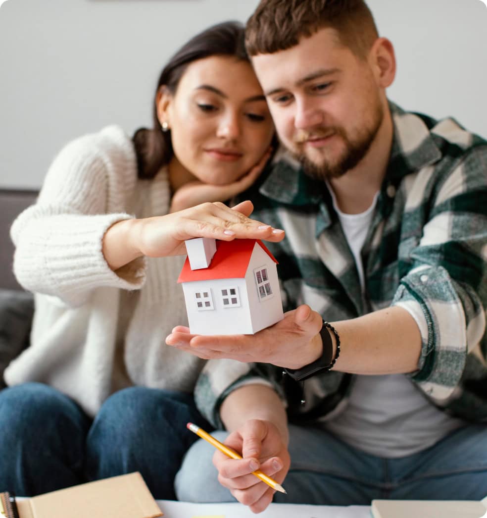 couple-holding-small-house-medium-shot